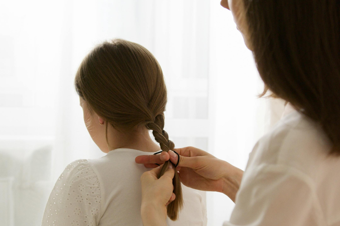 Mother braiding daughters hair